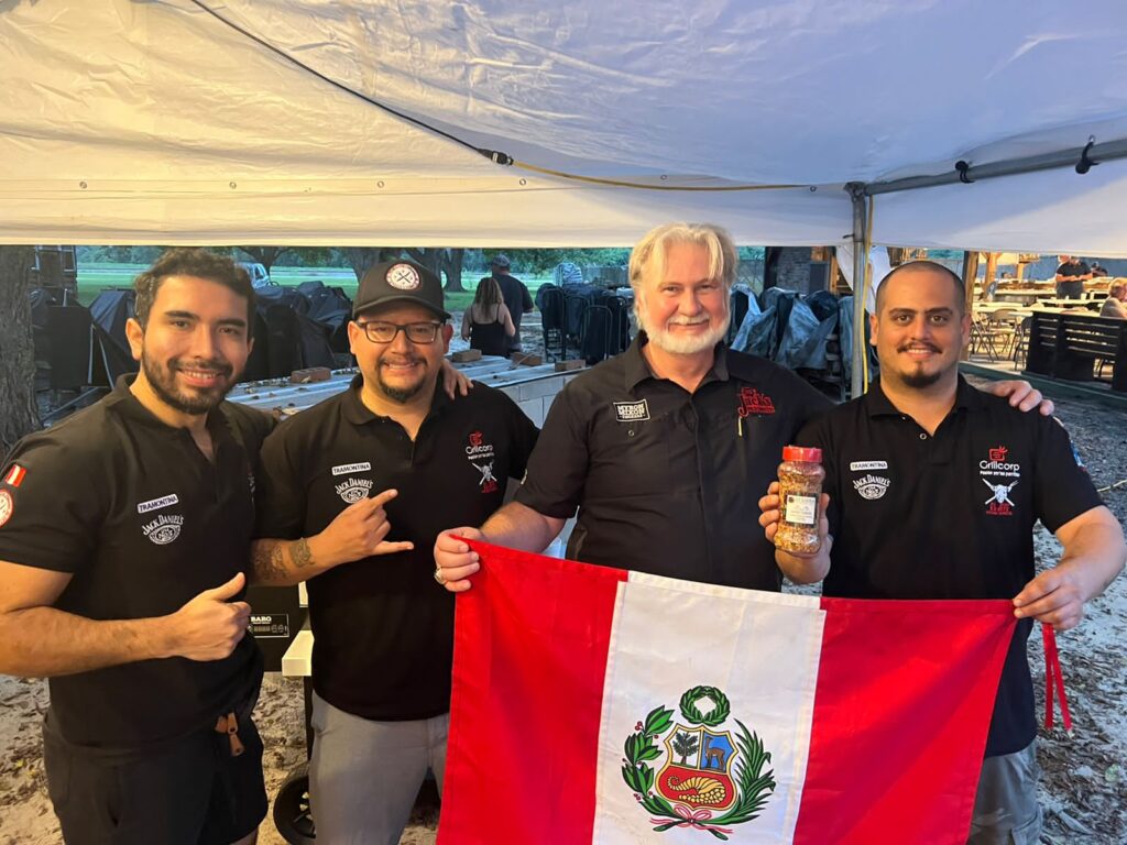 Stefano Zapatier y Myron Mixon sujetando una bandera del Perú junto a Jorge Geldres y Gabriel Cordero